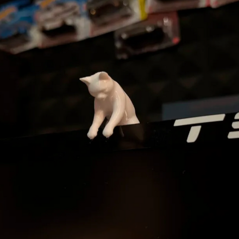 3D-printed cat peeking over the top of a monitor