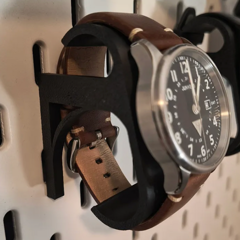 3D-printed pegboard watch holder cradling a watch